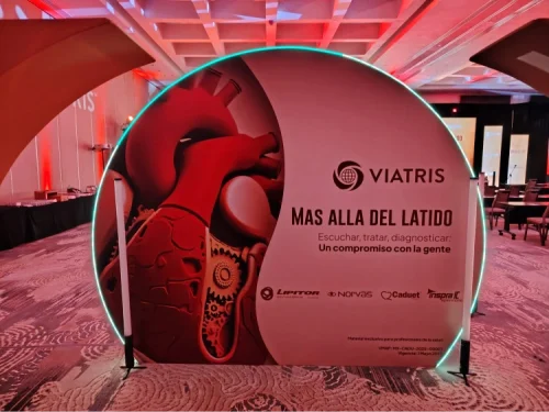 Diseño de escenografía corporativa con estructura circular iluminada y gráficos de marca para evento farmacéutico de Viatris.