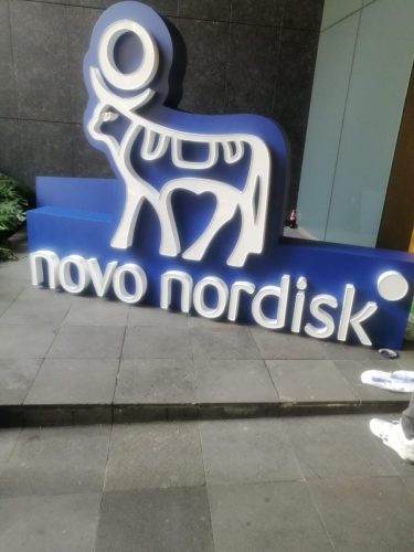 Logotipo 3D gigante de Novo Nordisk en letras azules y blancas fabricado para decoración y branding de evento corporativo.